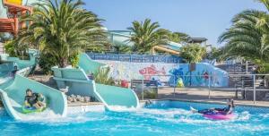a group of people riding down a water slide at a water park at Fairy Cove Cottage in Paignton