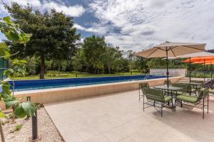 een terras met een tafel, stoelen en een parasol bij Hyatt Place Merida/ Via Montejo in Mérida
