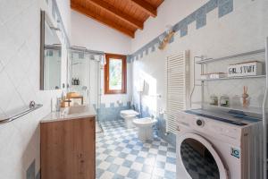a bathroom with a toilet and a sink and a washing machine at Green Hill apartment in Salò