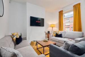 un soggiorno con un divano e una TV di The Bluebird B&B II a Headingley