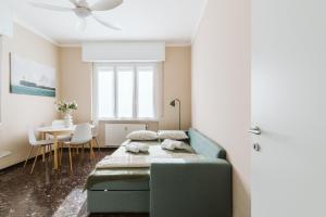 ein Schlafzimmer mit einem grünen Sofa und einem Tisch in der Unterkunft Mari's House centro wifi AC pet friendly in Recco
