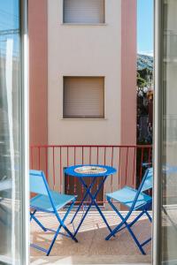 einen blauen Tisch und zwei Stühle auf dem Balkon in der Unterkunft Mari's House centro wifi AC pet friendly in Recco