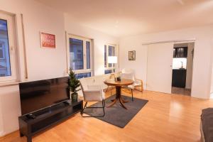 a living room with a table and a tv at Zweisam am Alaunpark  +4 photos