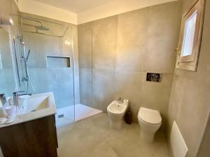 ISA - Luxury apartment Elicriso sea view with common swimming pool just 100 mt from the beach في غولفو أرانتْشي: حمام مع مرحاض ومغسلة ودش
