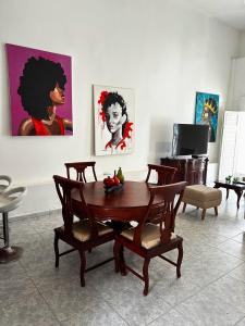a living room with a table and chairs and paintings at Art House Getsemaní in Cartagena de Indias +37 photos