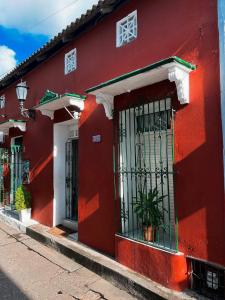 um edifício vermelho com janelas com barras numa rua em Art House Getsemaní em Cartagena de Indias