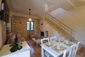 a kitchen and living room with a white table and chairs at Kastro-Kardamili in Kardamyli