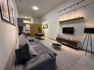 a living room with a couch and a flat screen tv at Loft Prime Andradina in Andradina