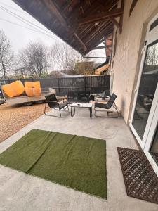 a green rug on a patio with chairs and a table at Suite Romantique avec balnéothérapie double & sauna Privés - Nuit s'exception in Briord