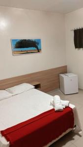 a bedroom with a bed with a red and white blanket at Pousada Tianguá in Luis Correia +13 photos