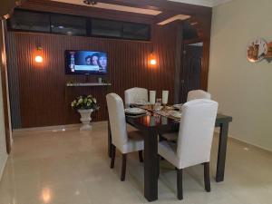 a dining room with a table and white chairs at Constanza Family House in Constanza