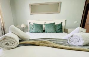 een slaapkamer met een bed met handdoeken erop bij Casa do Omega do Foz in Foz do Arelho