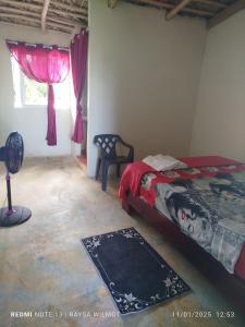 ein Schlafzimmer mit einem Bett, einem Fenster und einem Teppich in der Unterkunft Parador tropical in Las Galeras