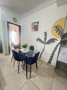 a dining room with a table and blue chairs at Wharf 303 in Pointe-Noire