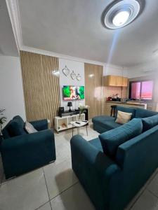 a living room with two blue couches and a kitchen at Wharf 303 in Pointe-Noire