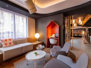 ein Wohnzimmer mit einer Couch und einem Tisch und Stühlen in der Unterkunft Novotel Suites Colmar Centre in Colmar