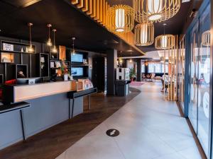 eine Lobby eines Restaurants mit einer Theke und Kronleuchtern in der Unterkunft Novotel Suites Colmar Centre in Colmar