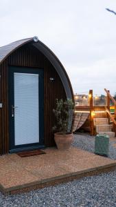 a building with a large door with a potted plant at Hidden Acres- Luxury Glamping Pod in Malahide