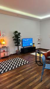 un soggiorno con TV a schermo piatto e tavolo di شقق ميد كانتري a Khamis Mushayt