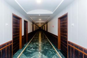 カリヤーンにあるHotel O Sai Plazaの部屋に水たまりがある長い廊下