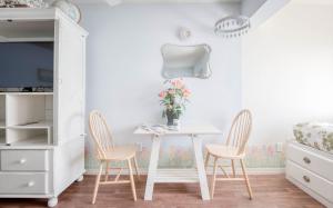 a white dining room with a table and two chairs at Coastal Garden - Anchor Pier Lodge in Newport
