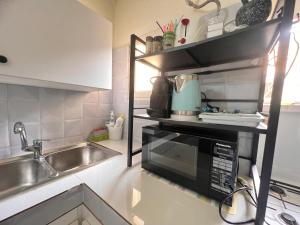 una cucina con lavello e microonde di chambre de standing a yoff virage N2 a Ngor