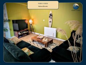 een woonkamer met een zwarte bank en een tv bij Terra Verde Appartement nature tout équipé près de Gap in Gap