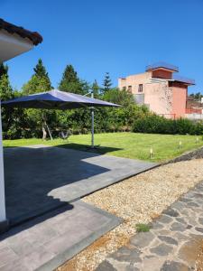 a patio with an umbrella on a sidewalk at Villa Luigi in Valverde