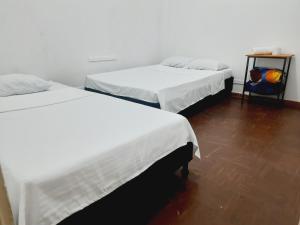 马尼萨莱斯Hotel Nevado Manizales的一间有两张床和一张桌子的房间，桌子上有一个背包