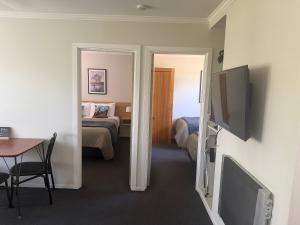 a room with a room with a bed and a television at Lumsden Motel in Lumsden