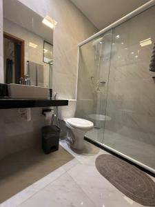 ein Badezimmer mit Dusche, Toilette und Waschbecken in der Unterkunft RM Hospedage Unidade Amapa 2 in Cabo Frio + 3 Fotos
