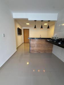 eine große Küche mit einer Theke in einem Zimmer in der Unterkunft RM Hospedage Unidade Amapa 2 in Cabo Frio