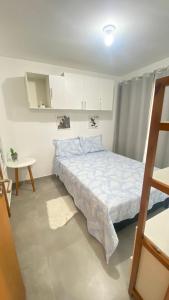 ein kleines Schlafzimmer mit einem Bett und einem Tisch in der Unterkunft Condomínio encantador com piscina in Ipojuca