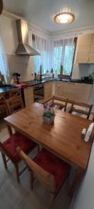 IHB-Inter House of Balaton في زاماردي: مطبخ مع طاولة خشبية مع كراسي ومطبخ