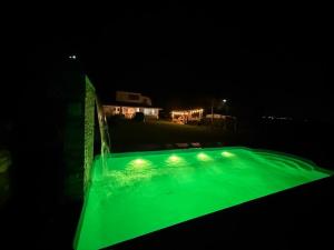a pool with green illumination at night at Casa de campo in San Antonio