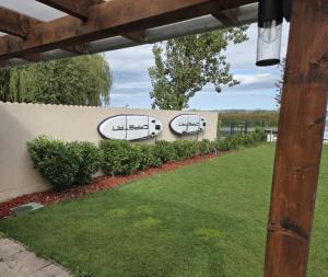 IHB-Inter House of Balaton في زاماردي: جدار استنادي عليه لافتة تشير إلى طاولة نزهة +صورتان