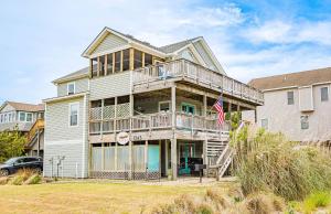 a large house with a balcony and an american flag at D3943 The Pup Deck - Oceanside, Pool, Hot Tub, Pets OK, Beach & Sound Access! in North Point
