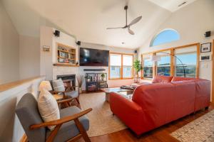 a living room with a red couch and a fireplace at D3943 The Pup Deck - Oceanside, Pool, Hot Tub, Pets OK, Beach & Sound Access! in North Point