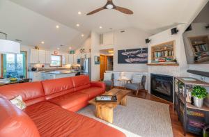 a living room with a red couch and a kitchen at D3943 The Pup Deck - Oceanside, Pool, Hot Tub, Pets OK, Beach & Sound Access! in North Point