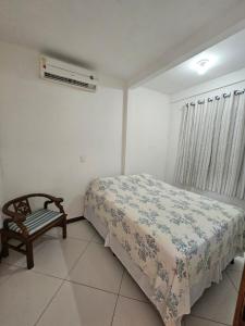 a bedroom with a bed and a chair in it at Ap Aconchego Carapitangui in Barra Grande