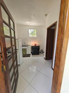 a kitchen with a refrigerator and a tile floor at Ap Aconchego Carapitangui in Barra Grande +2 photos