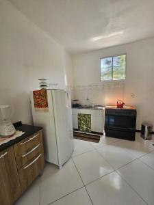 a kitchen with a refrigerator and a stove in it at Ap Aconchego Carapitangui in Barra Grande