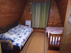 a bedroom with two beds in a log cabin at Vikendica Luna in Gornja Šišava