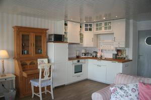 una cucina con mobili bianchi, un tavolo e un divano di Aurelia's Meerblick a Hansaland Altre 8 foto