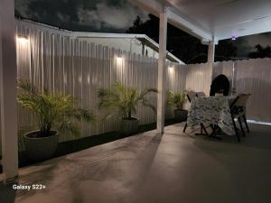 un patio con un tavolo e piante in vaso di notte di Close to hard rock stadium and guitar casino a Pembroke Pines