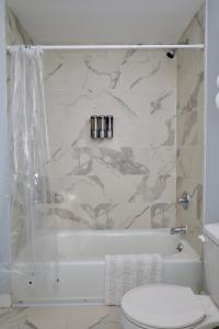 a bathroom with a white tub and a toilet at Modern Lakeview Escape | Scenic Deck • Fire Pit in Monroe +43 photos