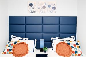 a bedroom with a blue headboard and two white pillows at Modern Lakeview Escape | Scenic Deck • Fire Pit in Monroe