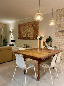 a dining room with a wooden table and white chairs at Casa Della Baia With a beautiful view in Varazze