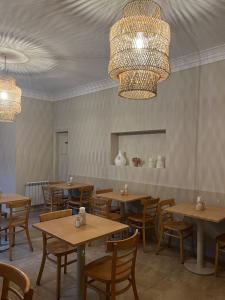 Un restaurante con mesas y sillas de madera y lámparas de araña. en Hotel Ideal, en Miramar