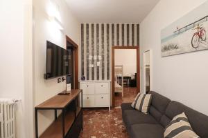 een woonkamer met een bank en een tv bij Charming 2 Suite Apt - 20 min Colosseo & Metro 5 min in Rome